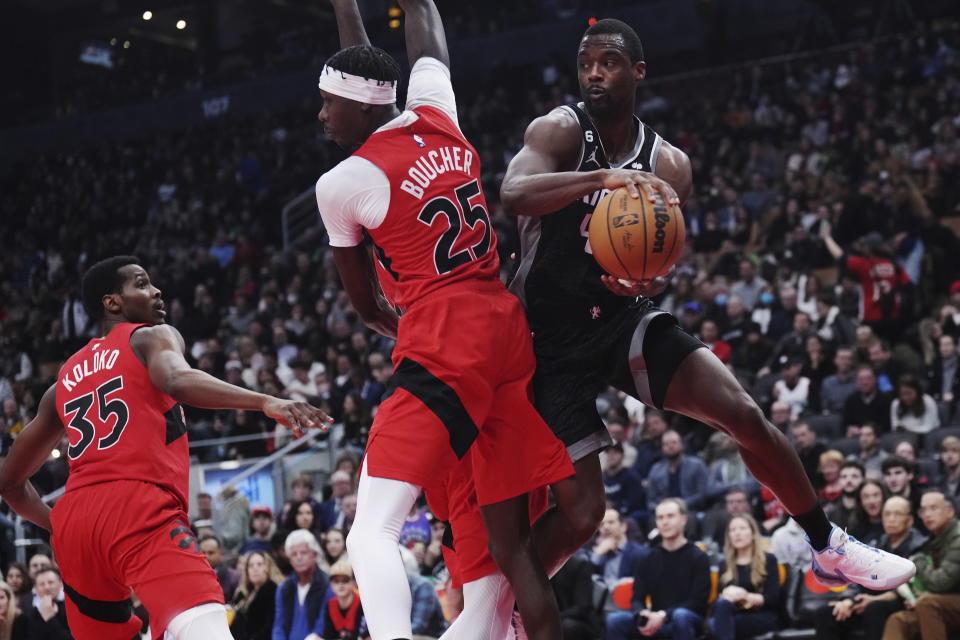 Sacramento Kings forward Harrison Barnes (40) passes the ball around Toronto Raptors forward Chris Boucher (25) during the second half of an NBA basketball game in Toronto on Wednesday, Dec. 14, 2022. (Nathan Denette/The Canadian Press via AP)