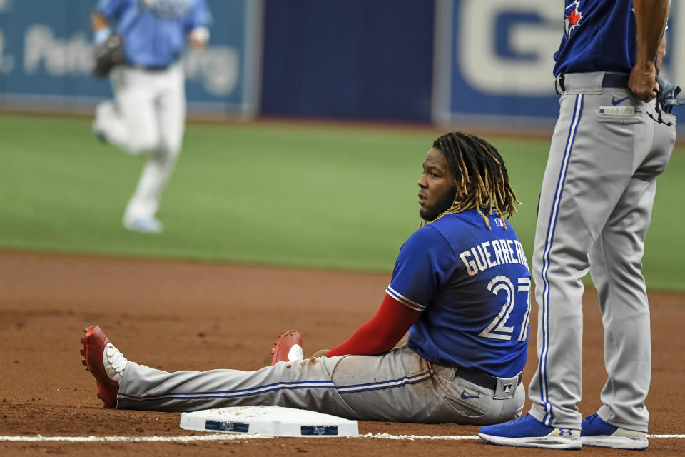 Toronto Blue Jays' Vladimir Guerrero Jr. sits in the dirt after he was picked off first base on a throw from Tampa Bay Rays catcher Mike Zunino during the first inning of a baseball game Saturday, July 10, 2021, in St. Petersburg, Fla. (AP Photo/Steve Nesius)