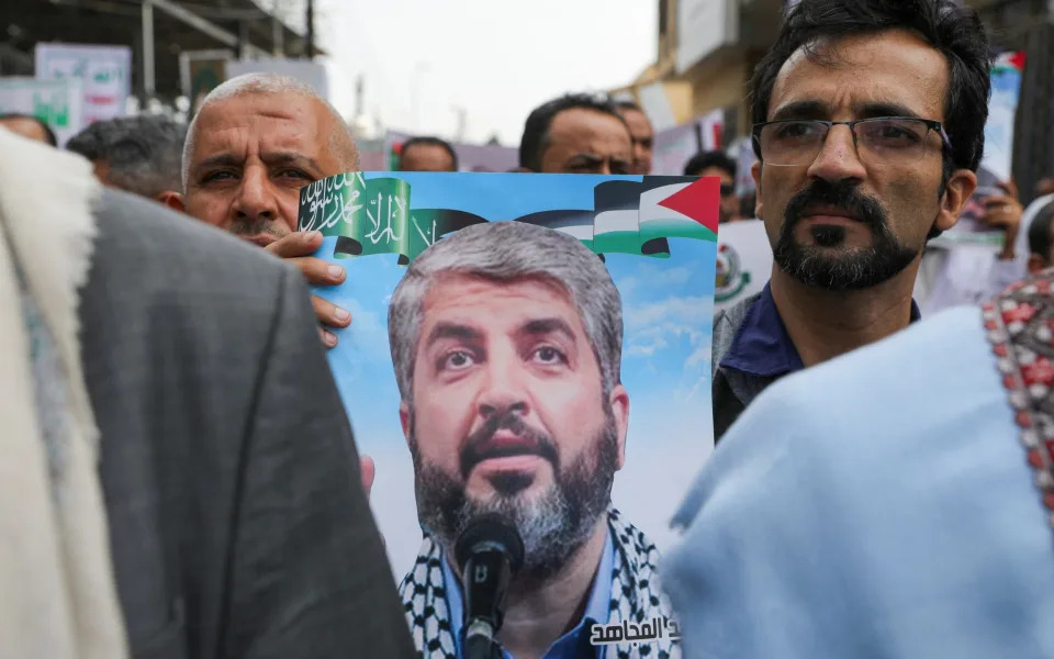 A protester holds a poster of Khaled Meshaal during a protest to show solidarity with Palestinian prisoners outside the United Nations offices in Sanaa, Yemen