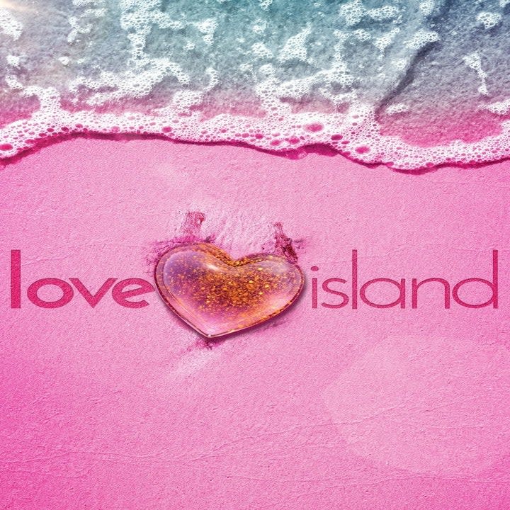 Pink sand with a heart in it with water coming up, Love island etched in sand.