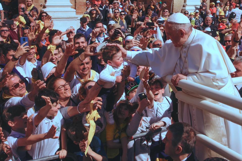 Pope Francis caresses a child as he leaves the Basilica of Our Lady of Loreto where he celebrated mass and prayed in the shrine containing a small house traditionally venerated as the house of Mary, and believed miraculously transplanted from the Holy Land inside the Basilica, in central Italy, during a one-day visit, Monday, March 25, 2019. The pope chose Loreto to sign the Post-Synodal Exhortation of last October's Synod of Bishops. (AP Photo/Domenico Stinellis)