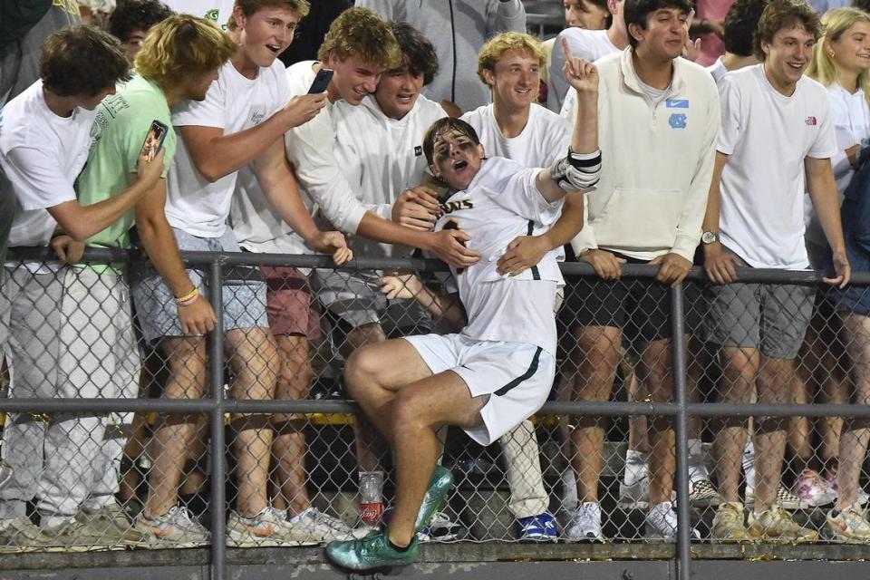 Cardinal Gibbons’ Charlie Carmouche (6) celebrates with fans in the stands after their victory over Charlotte Catholic in the NCHSAA 4A Boys Lacrosse Finals. The Charlotte Catholic Cougars and the Cardinal Gibbons Crusaders met in the NCHSAA 4A Girls Lacrosse Final in Durham , NC on May 19, 2023.