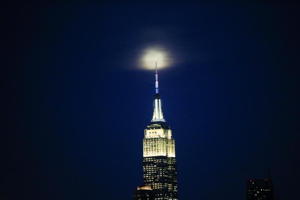 The supermoon is seen above the Empire State Building in New York (REUTERS)