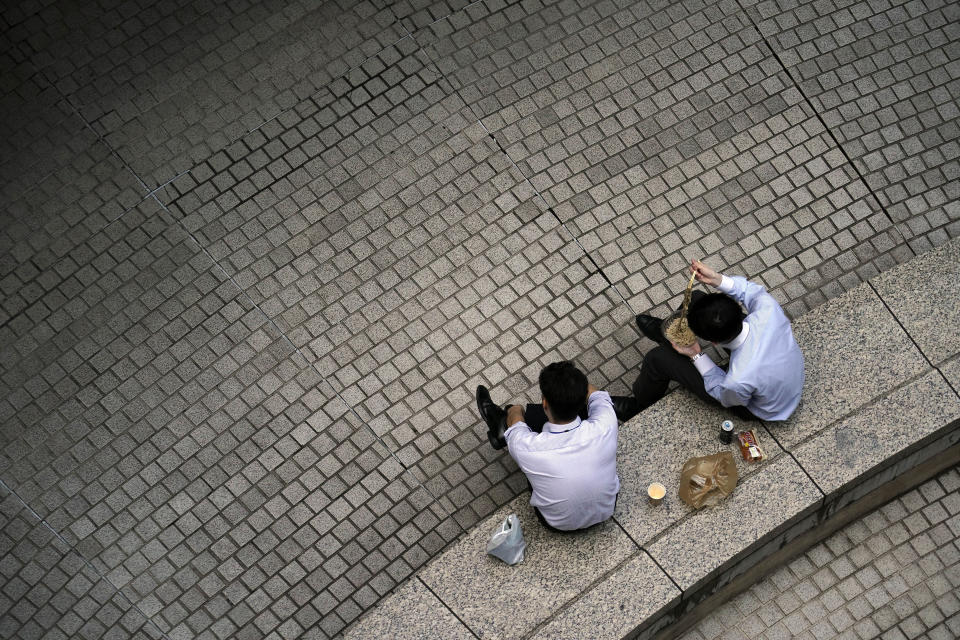 Men have lunch at a court Wednesday, May 27, 2020, in Tokyo. Japanese Prime Minister Shinzo Abe announced the lift of a coronavirus state of emergency from Tokyo and four other remaining areas on Monday, ending the restrictions nationwide as businesses begin to reopen. (AP Photo/Eugene Hoshiko)