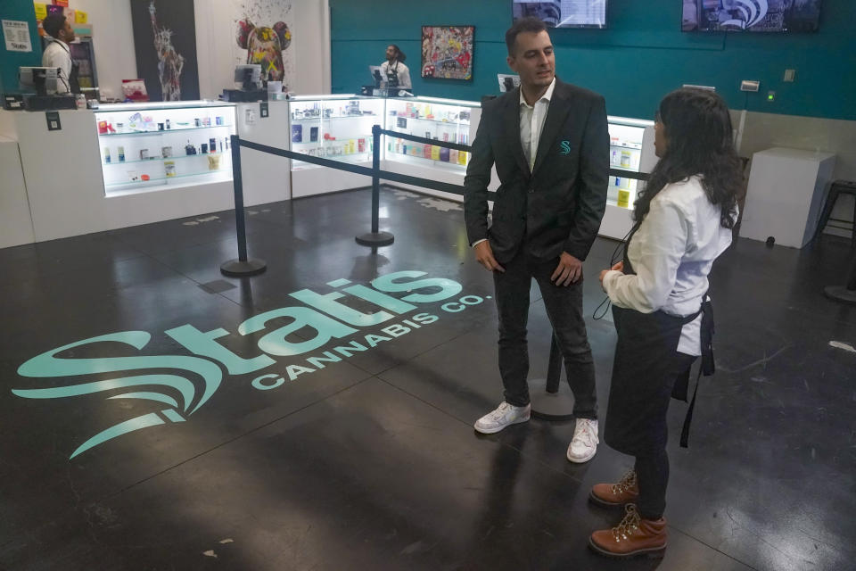 Brandon Bianco, operations manager for Statis Cannabis Company dispensary, left, confers with Alex Silecchia, right, a store budtender, also known as a sales associate, tender, Friday, Sept. 29, 2023, in New York. Bianco agrees "there is enough business to go around," as New York is set to dramatically expand its legal weed market and issue more than 1,000 new licenses. (AP Photo/Bebeto Matthews)