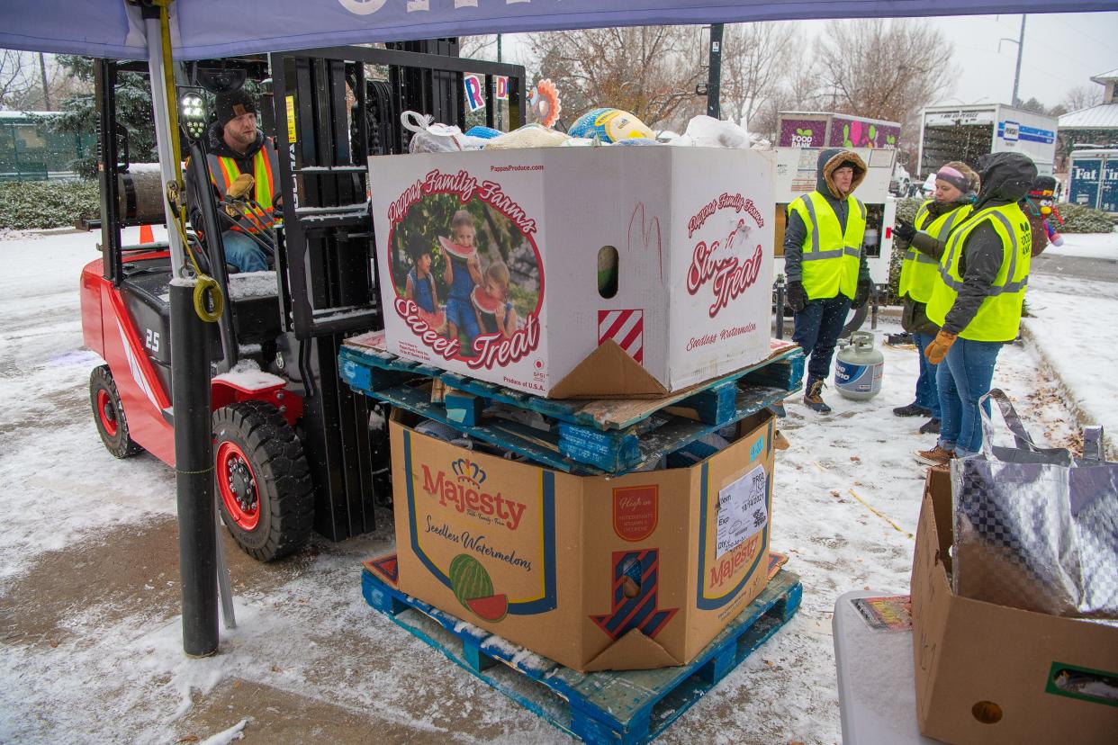 A Food Bank for Larimer County worker moves two containers of donated turkeys during the Tour de Turkey event Thursday, Nov. 17, 2022, at the Drake Center parking lot in Fort Collins, Colo. Food Bank officials expect a big boost in volunteer help from a new program at Colorado State University that will pay eligible employees for up to 8 hours of work each year with their organization and other nonprofits in Larimer and Weld County.
