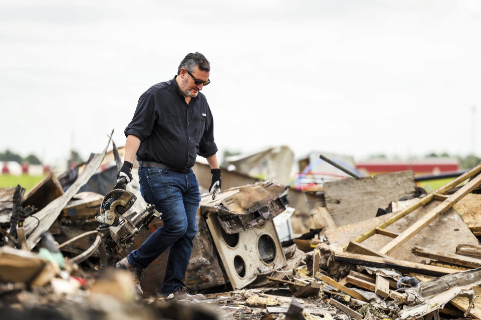 U.S. Sen. Ted Cruz, R-Texas, carries an item from debris in a trailer park that was damaged by a tornado in Perryton, Texas, Saturday, June 17, 2023. (AP Photo/David Erickson)
