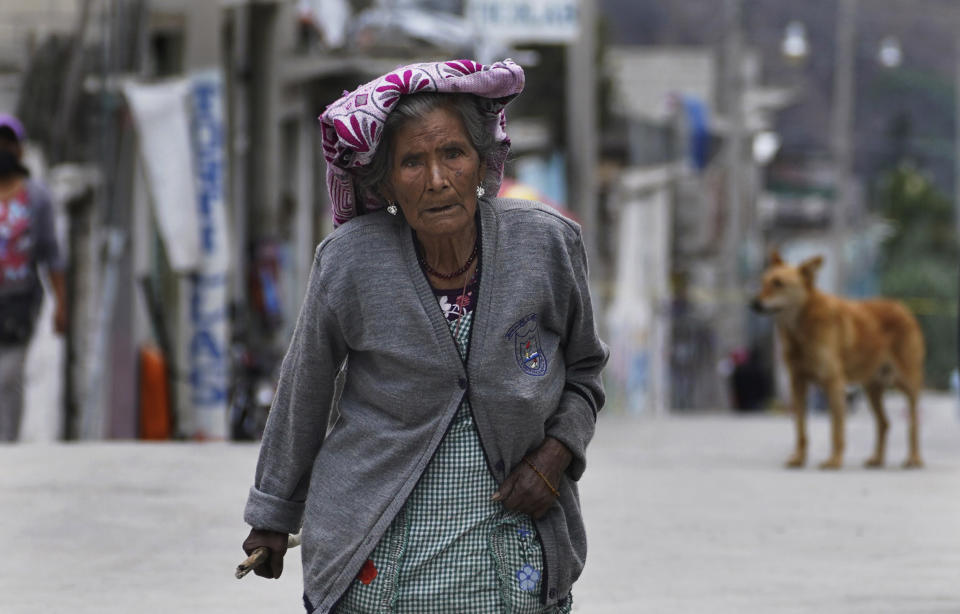 Una mujer camina sobre las calles cubiertas con la ceniza del volcán Popocatépetl, el lunes 22 de mayo de 2023, en Santiago Xalitzintla, México. (AP Foto/Marco Ugarte)