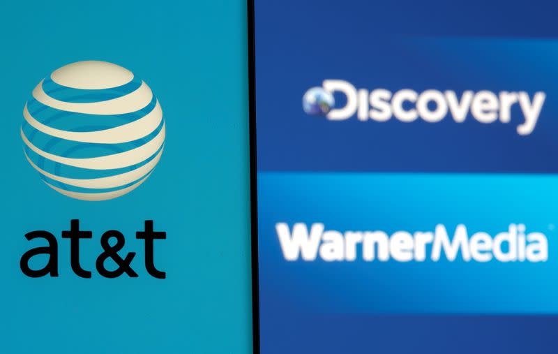 AT&T logo is seen on a smartphone in front of displayed Discovery and Warner Media logos in this illustration