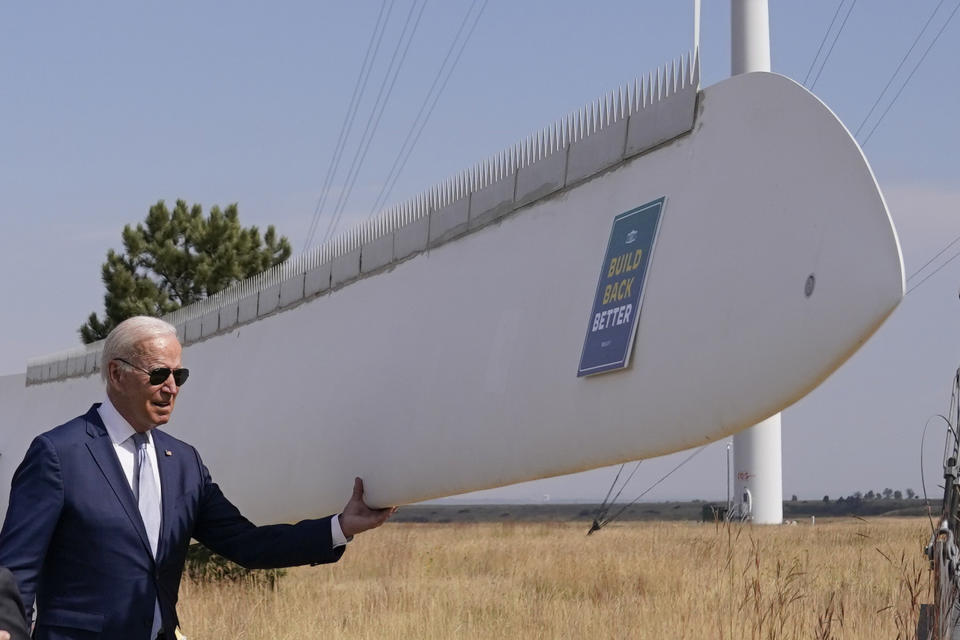 President Joe Biden holds onto a wind turbine blade during a tour at the Flatirons campus of the National Renewable Energy Laboratory, Tuesday, Sept. 14, 2021, in Arvanda, Colo. (AP Photo/Evan Vucci)