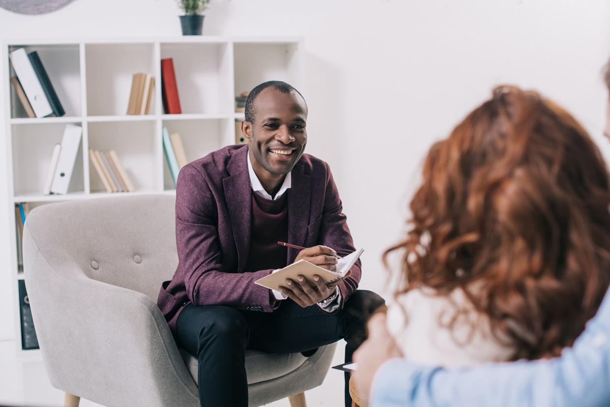 smiling psychiatrist talking to young couple