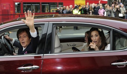 Paul McCartney (L) and his new wife Nancy Shevell (R) wave to fans as the leave Marylebone registry office in central London. McCartney married for the third time on Sunday, tying the knot with New York heiress Shevell at the same London venue where he married his first wife