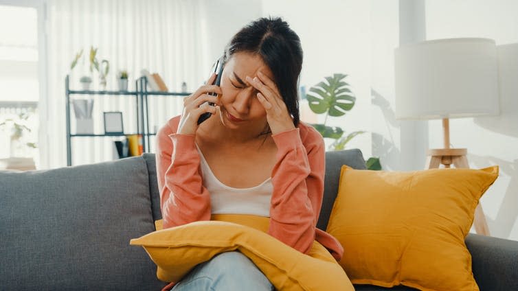 A woman on her phone, struggling to concentrate