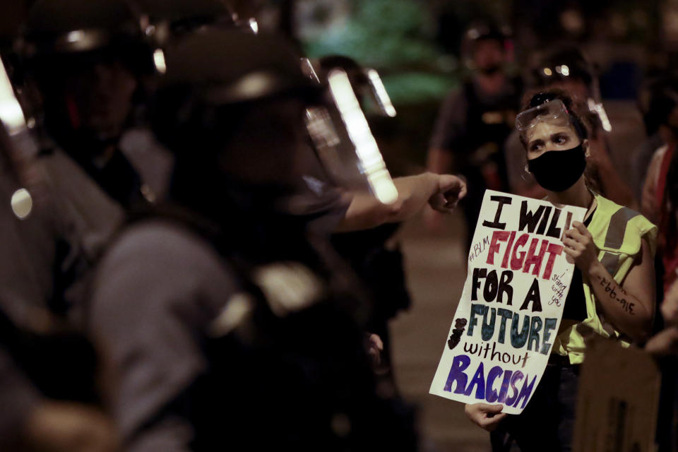 A protester confronts a line of police in riot gear early Thursday, June 4, 2020, in Kansas City, Mo., after a unity march to protest against police brutality following the death of George Floyd, who died after being restrained by Minneapolis police officers on May 25. As a new generation steps up, activists and historians believe there’s important work to be done for white people: Listening to black voices and following rather than trying to lead, for one, and the deep introspection it takes to confront unconscious bias and the perks of privilege that come just from being white. (AP Photo/Charlie Riedel)