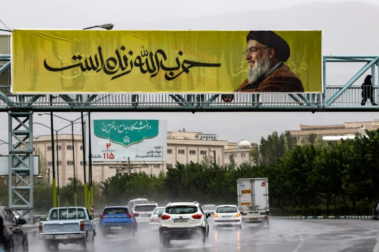 Un afiche con un retrato del fallecido líder de Hezbolá, Hasán Nasralá con el mensaje en farsi "Hezbolá vive" en un puente en el norte de Teherán, el 28 de septiembre de 2024 (ATTA KENARE)