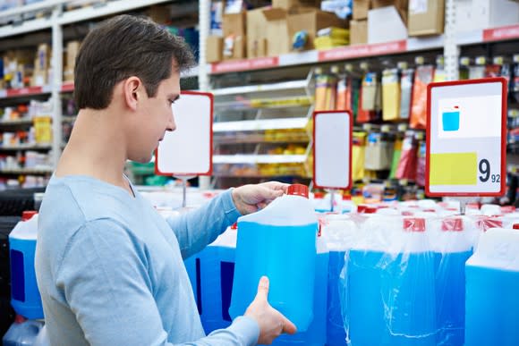 A shopper picks out windshield wiper fluid.