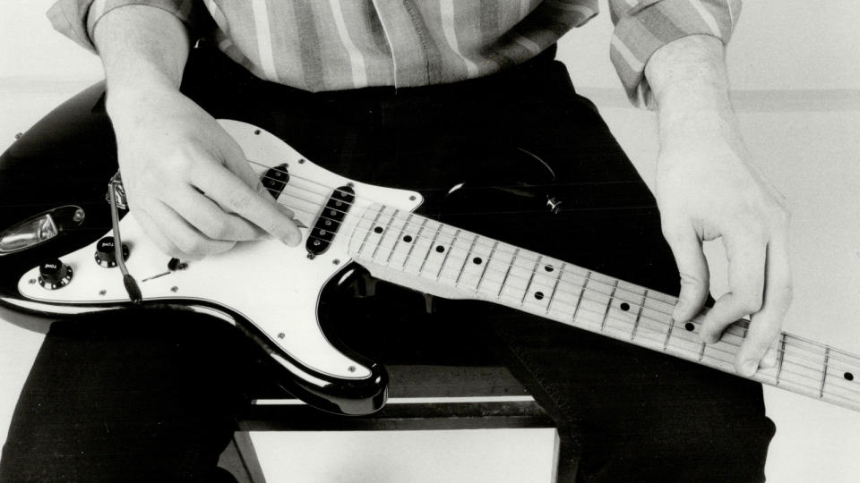 Jeff Healey plays a Stratocaster style guitar on his lap. Caption: Jeff Healey has tried conventional guitar playing. But it was too hard to work with. 