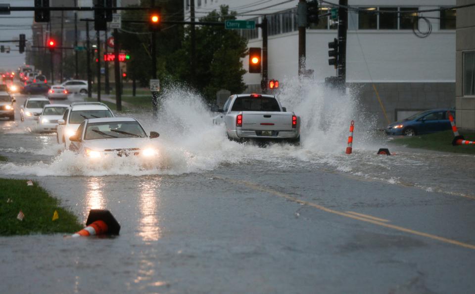 Cars drive though a flooded intersection at Kimbrough Avenue and Cherry Street on Monday, Aug. 29, 2022. Heavy rain caused flash flooding across Springfield.