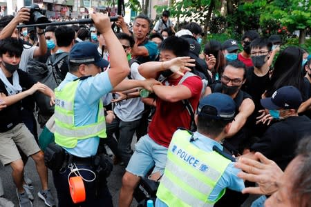 Police swing their batons at protesters as they try to disperse pro-democracy activists after a march at Sheung Shui in Hong Kong