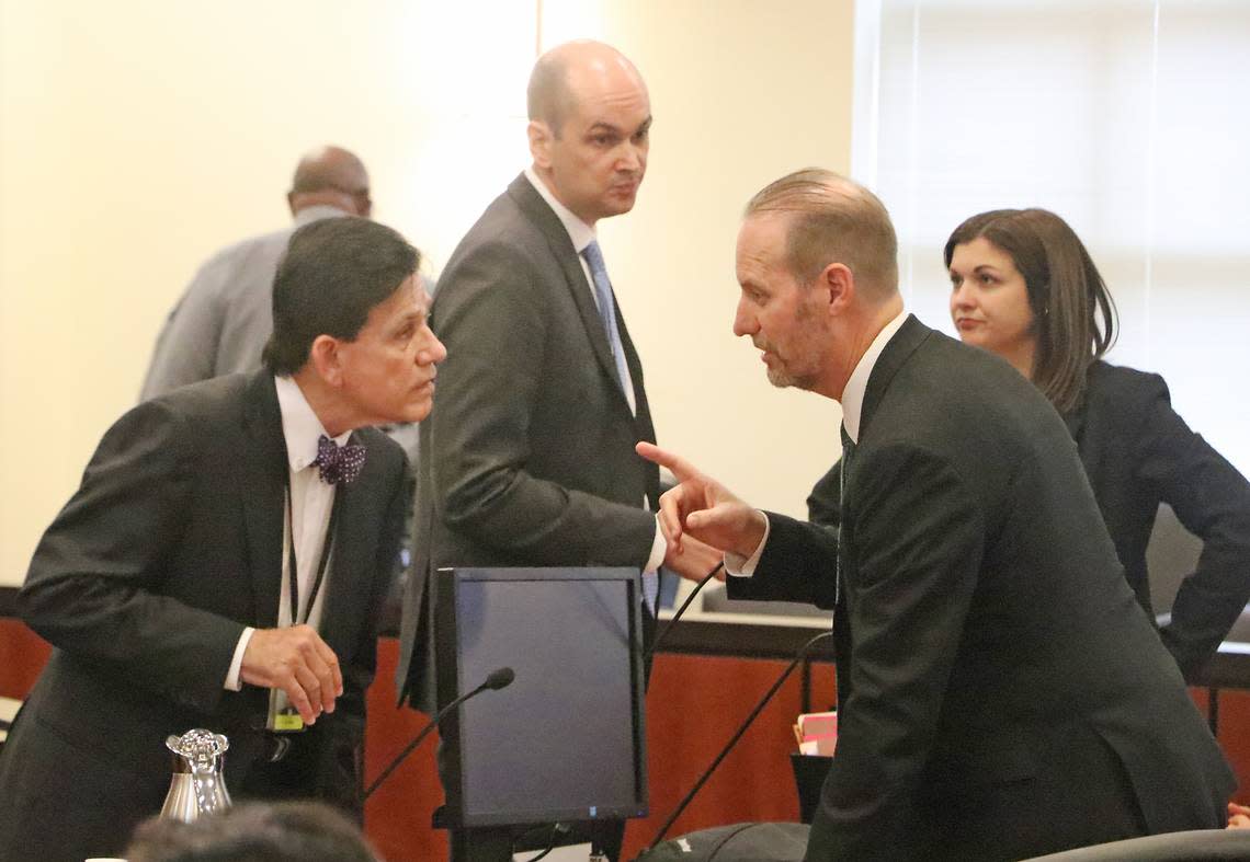 Attorney Michael Mills, left, who represented Jody Greene in his removal hearing Monday morning, speaks with District Attorney Jon David during a recess.