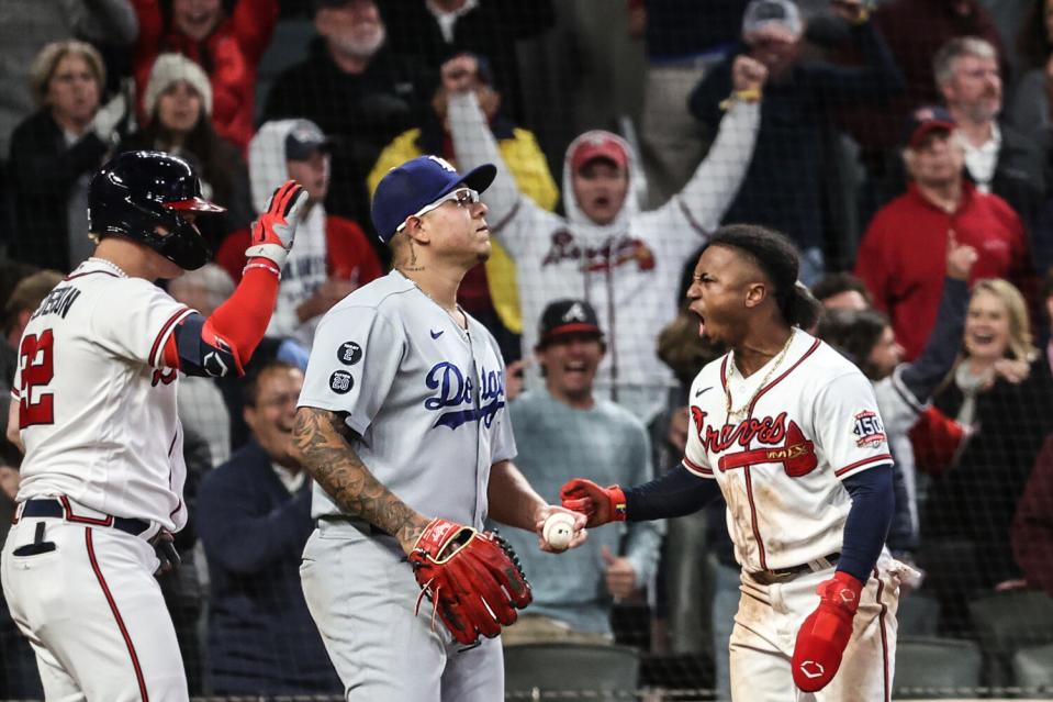 Atlanta Braves teammates Freddie Freeman and Ozzie Albies celebrate after scoring the tying run.