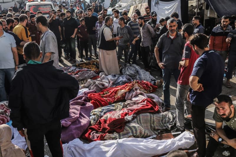 Palestinians inspect the bodies of victims who were killed in Israeli bombardment as they lie outside Al-Shifa hospital, amid ongoing battles between Israel and the Palestinian group Hamas. Mohammad Abu Elsebah/dpa