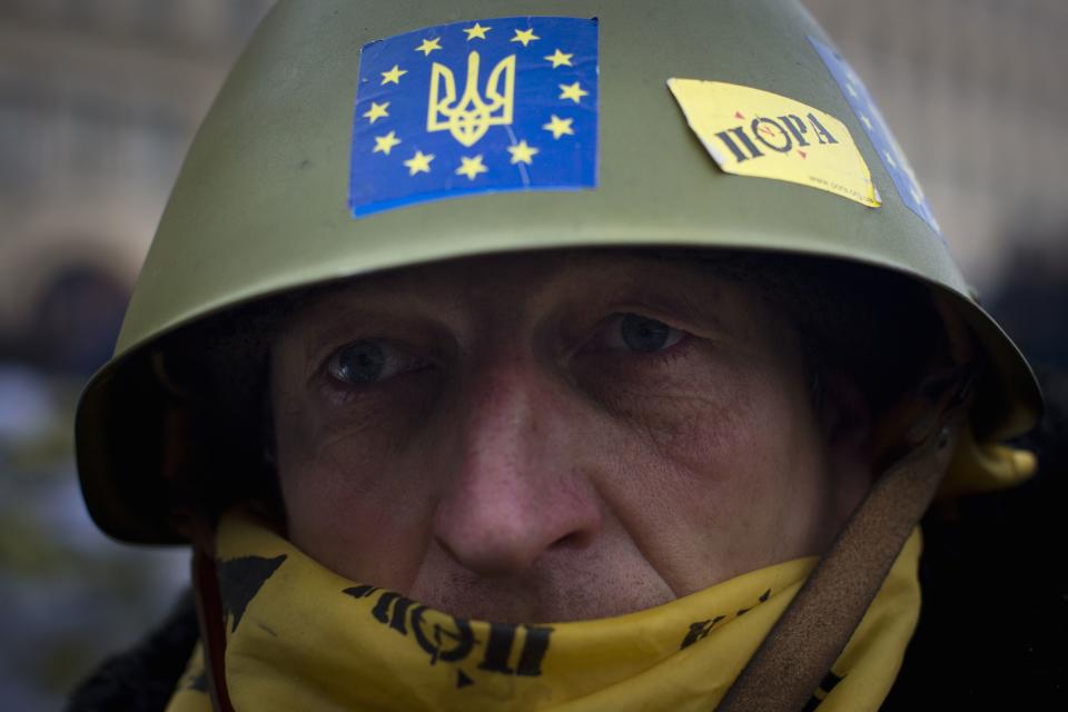 An anti-government protester poses for a portrait at the barricades near the site of clashes with riot police in Kiev