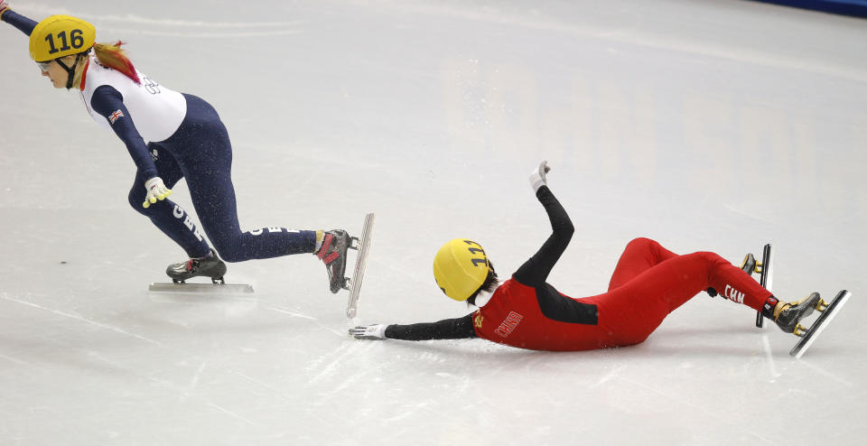 Elise Christie of Britain, left, and Li Jianrou of China crash out in a women's 1000m short track speed skating semifinal at the Iceberg Skating Palace during the 2014 Winter Olympics, Feb. 21, 2014, in Sochi, Russia.
