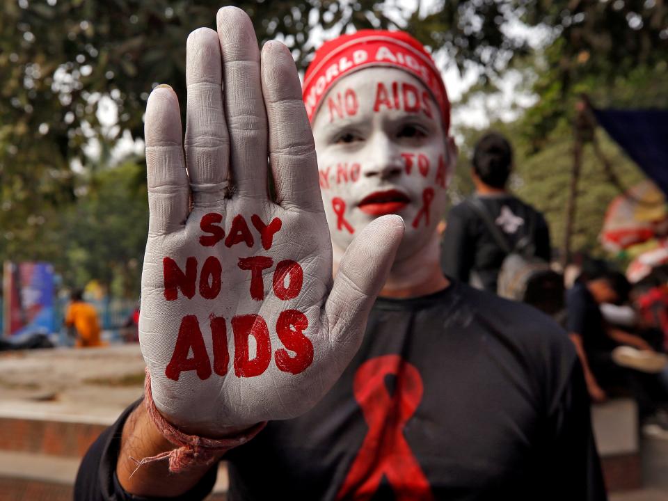 FILE PHOTO: A man poses as he displays his hand and face painted with messages during an HIV/AIDS awareness campaign on the eve of World AIDS Day in Kolkata, India, November 30, 2018. REUTERS/Rupak De Chowdhuri