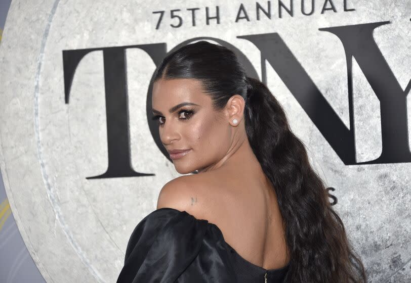 A woman in a strapless dress look over her left shoulder