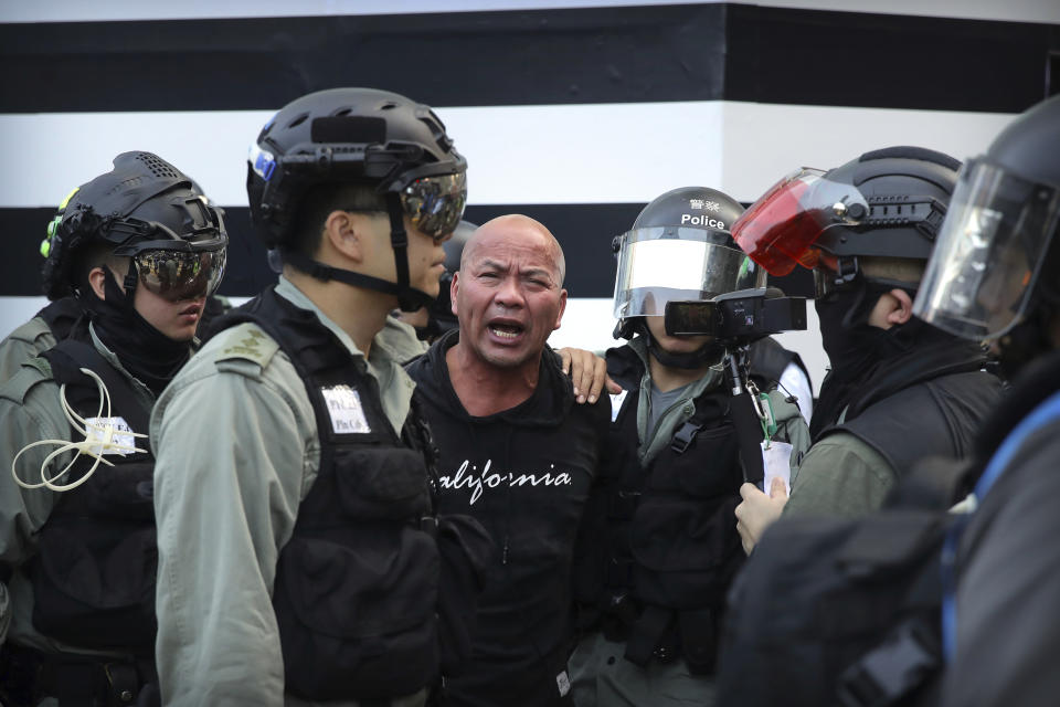 Police officers in riot gear detain a man during an anti-government protest in Hong Kong, Saturday, Nov. 2, 2019. Defying a police ban, thousands of black-clad masked protesters are streaming into Hong Kong's central shopping district for another rally demanding autonomy in the Chinese territory as Beijing indicated it could tighten its grip. (AP Photo/Kin Cheung)
