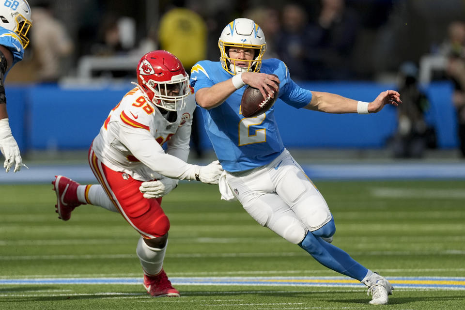 Los Angeles Chargers quarterback Easton Stick, right, scrambles away from Kansas City Chiefs defensive tackle Tershawn Wharton during the first half of an NFL football game, Sunday, Jan. 7, 2024, in Inglewood, Calif. (AP Photo/Mark J. Terrill)