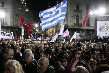 Supporters wave a Greek national flag as opposition leader and head of radical leftist Syriza party, Alexis Tsipras delivers a speech during a campaign in central Athens, January 22, 2015. REUTERS/Yannis Behrakis
