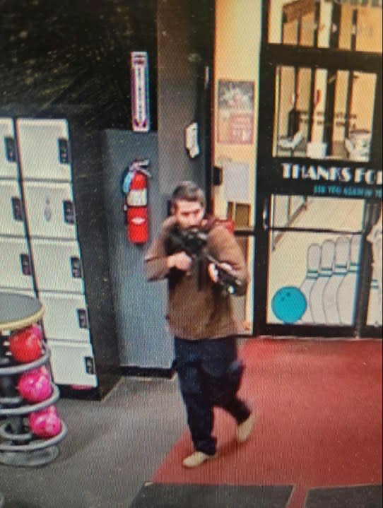 In this image taken from video released by the Androscoggin County Sheriff’s Office, an unidentified gunman points a gun while entering Sparetime Recreation in Lewiston, Maine, on Wednesday, Oct. 25, 2023. Maine State Police ordered residents in the state’s second-largest city to shelter in place Wednesday night as the suspect remains at large. (Androscoggin County Sheriff’s Office via AP)