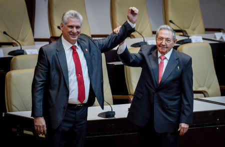 Newly elected Cuban President Miguel Diaz-Canel (L) reacts as former Cuban President Raul Castro raises his hand during the National Assembly in Havana, Cuba. REUTERS/Adalberto Roque/Pool via Reuters