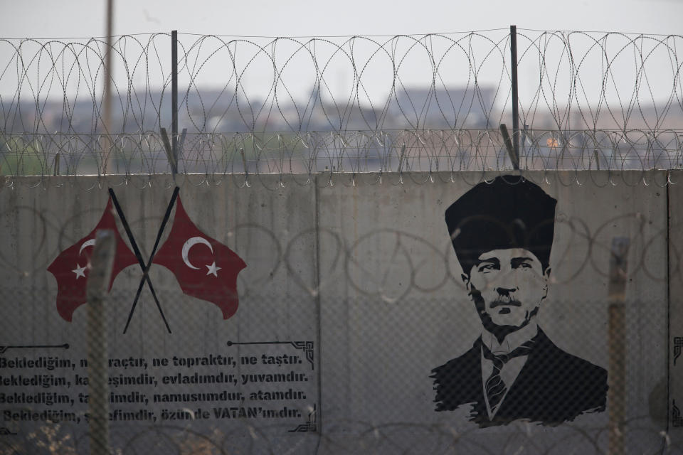 A graffiti of modern Turkey's founder Mustafa Kemal Ataturk is seen on the Turkish side of the border between Turkey and Syria, in Akcakale, Sanliurfa province, southeastern Turkey, Tuesday, Oct. 8, 2019. Turkey's vice president Fuat Oktay says his country won't bow to threats in an apparent response to U.S. President Donald Trump's warning to Ankara about the scope of its planned military incursion into Syria.(AP Photo/Lefteris Pitarakis)