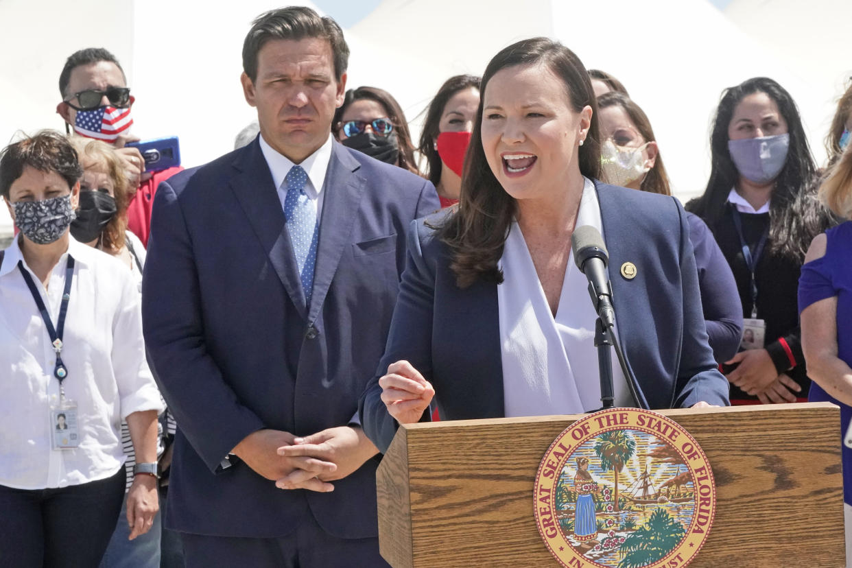 Florida Attorney General Ashley Moody speaks alongside Gov. Ron DeSantis during a news conference, Thursday, April 8, 2021, at PortMiami in Miami. DeSantis announced a lawsuit against the federal government and the CDC demanding that cruise ships be allowed to sail. (AP Photo/Wilfredo Lee)