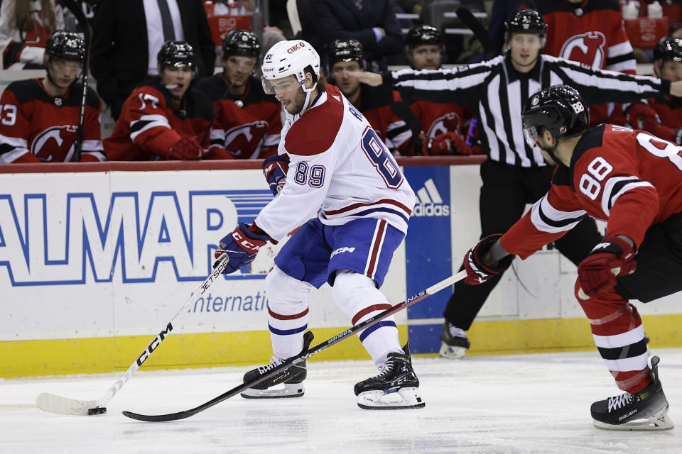 Montreal Canadiens right wing Joshua Roy (89) controls the puck past New Jersey Devils defenseman Kevin Bahl during the first period of an NHL hockey game Wednesday, Jan. 17, 2024, in Newark, N.J. (AP Photo/Adam Hunger)