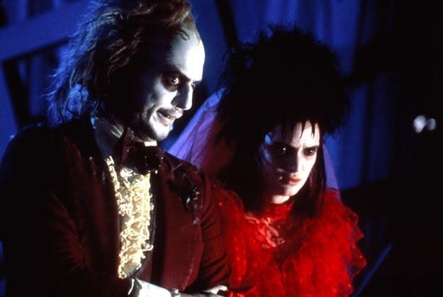 Michael Keaton and Winona Ryder standing side-by-side in a scene from "Beetlejuice"