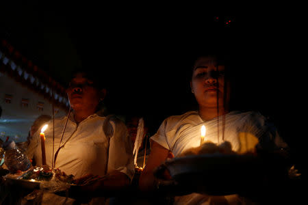 People hold offerings while praying for loved ones who have passed away during the first day of Pchum Ben festival, or the festival of the dead in Phnom Penh, Cambodia, September 25, 2018. REUTERS/Samrang Pring