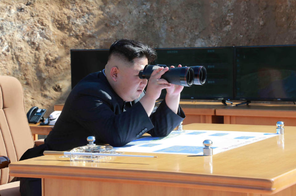 North Korean leader Kim Jong-Un holds binoculars.