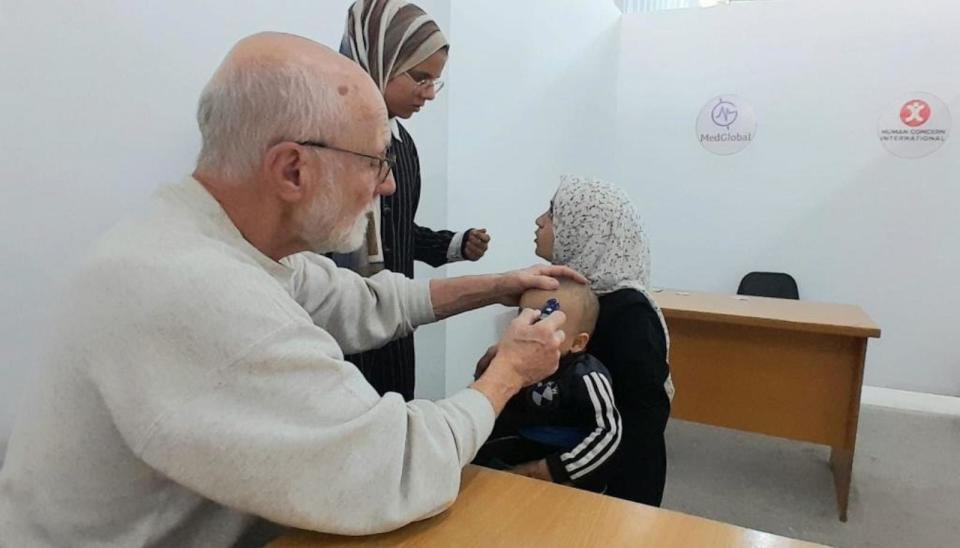 PHOTO: Dr. John Kahler from MedGlobal treats a young patient at a clinic in Gaza, January 2024. (MedGlobal)