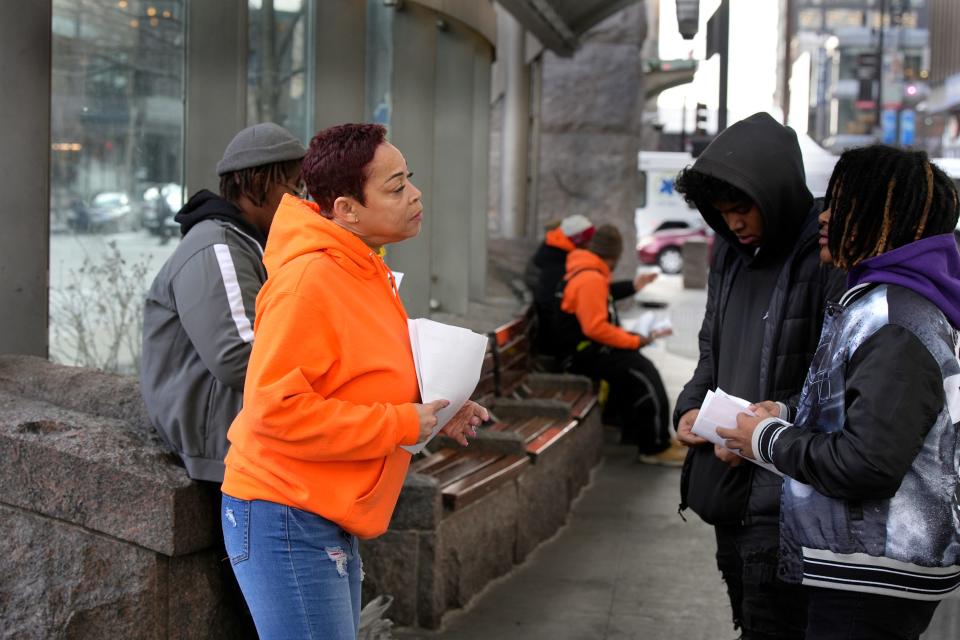 Michelle Robinson with Urban League's Community Partnering Center talks with teens about job opportunities while they wait for a bus at Government Square on Thursday.