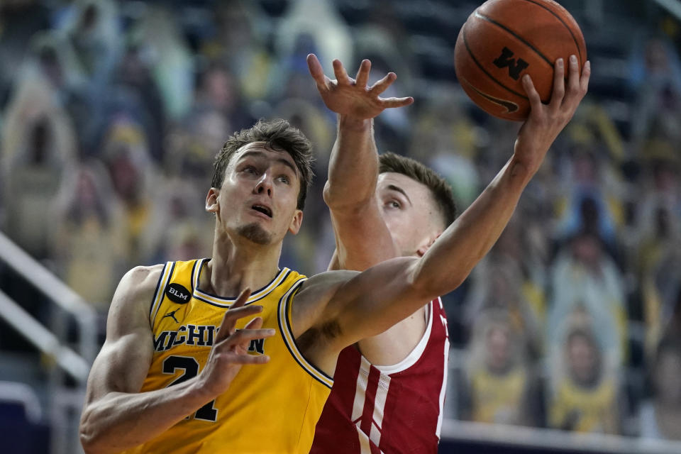 Michigan guard Franz Wagner (21) makes a layup as Wisconsin forward Micah Potter (11) defends during the second half of an NCAA college basketball game Tuesday, Jan. 12, 2021, in Ann Arbor, Mich. (AP Photo/Carlos Osorio)
