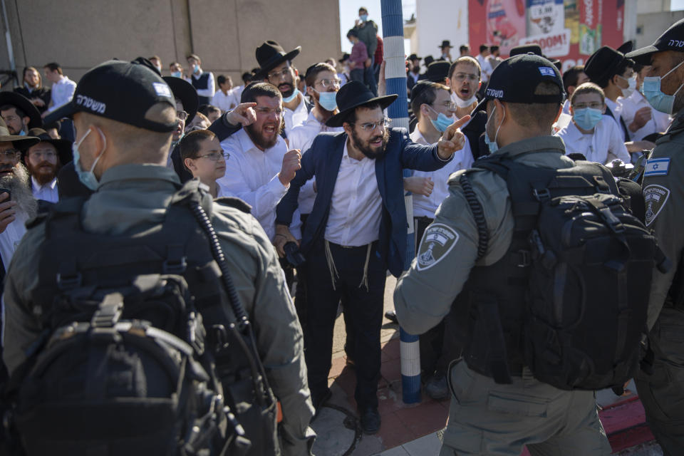 File - In this Sunday, Jan. 24, 2021 file photo, Ultra-Orthodox Jews argue with Israeli border police officers during a protest over the coronavirus lockdown restrictions, in Ashdod, Israel. (AP Photo/Oded Balilty, File)