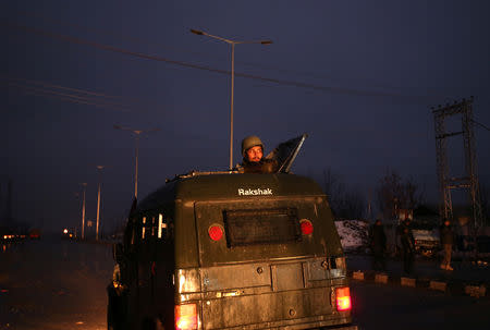 An Indian soldier keeps guards from atop an armoured vehicle near the site of explosion in Lethpora in south Kashmir's Pulwama district February 14, 2019. REUTERS/Danish Ismail