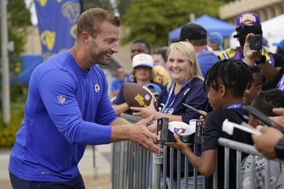 Los Angeles Rams head coach Sean McVay, left, signs autographs for fans at the NFL football team's practice facility in Irvine, Calif. Sunday, July 31, 2022. (AP Photo/Ashley Landis)