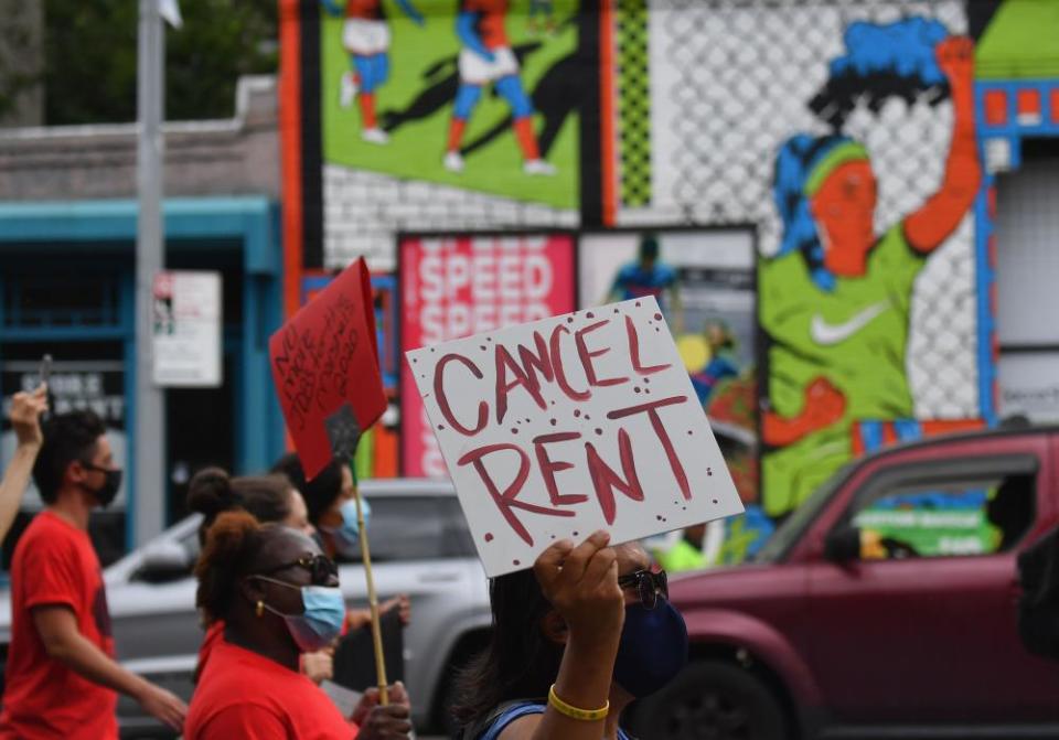 Protesters hold signs calling for rent to be cancelled.