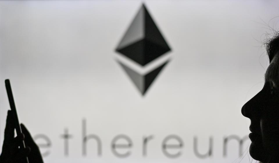 An image of a woman holding a cell phone in front of the Ethereum logo displayed on a computer screen.
On Tuesday, January 12, 2021, in Edmonton, Alberta, Canada. (Photo by Artur Widak/NurPhoto via Getty Images)