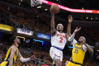 New York Knicks guard Miles McBride (2) shoots between Indiana Pacers guard Tyrese Haliburton, left, and center Myles Turner (33) during the first half of Game 6 in an NBA basketball second-round playoff series, Friday, May 17, 2024, in Indianapolis. (AP Photo/Michael Conroy)